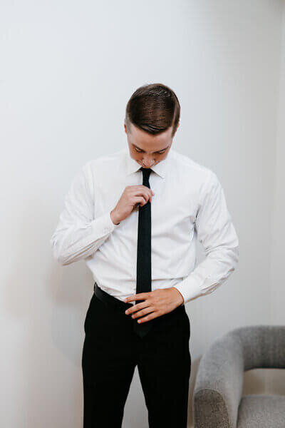 Groom fixing tie planned by luxury wedding planner chicago