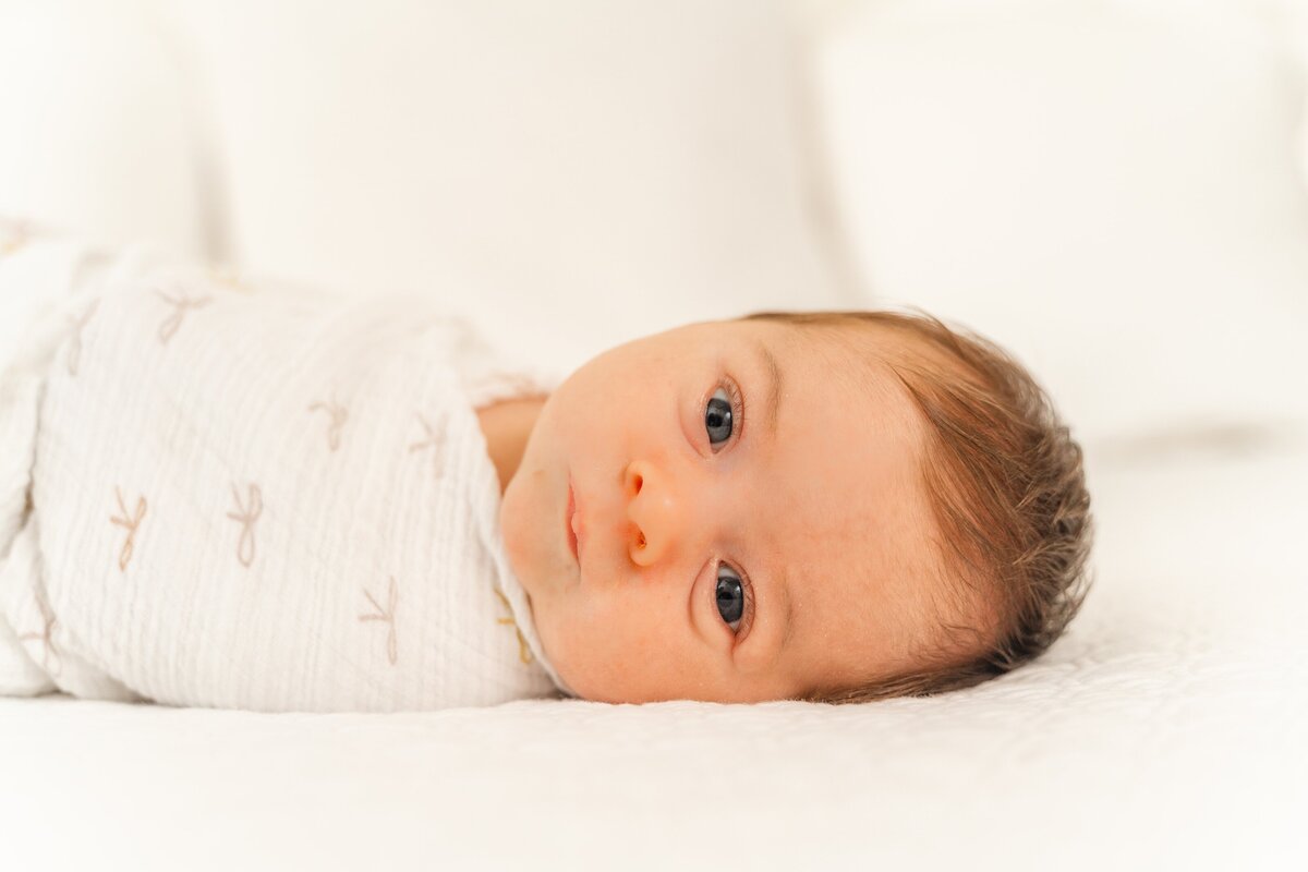 Image of newborn in white swaddle during in-home photography session with Chattanooga Photographer