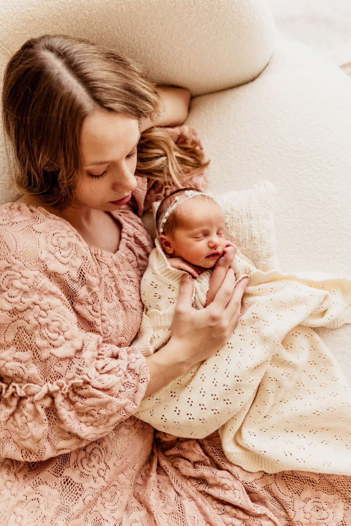 Mother with her 7 day old daughter who is wrapped in a white blanket.