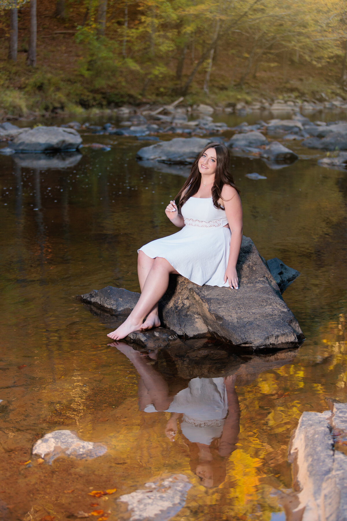 Sitting on a rock in the river near Raleigh NC for senior pictures