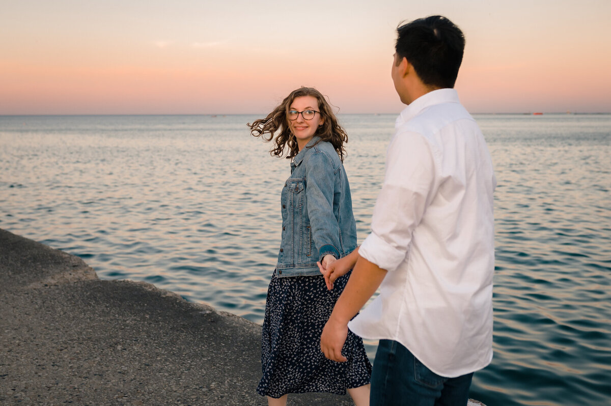 A women holds hands with a man on Lake Michigan