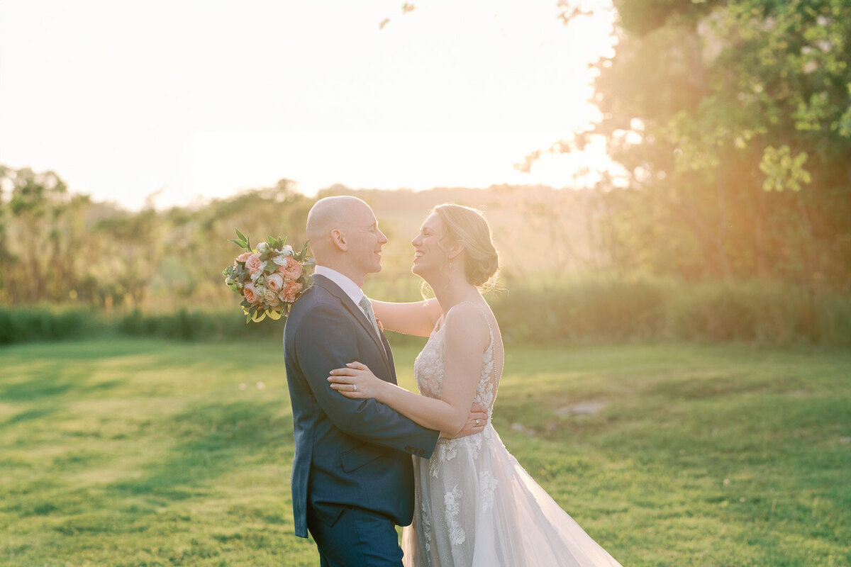 bride and groom embrace during a sunset