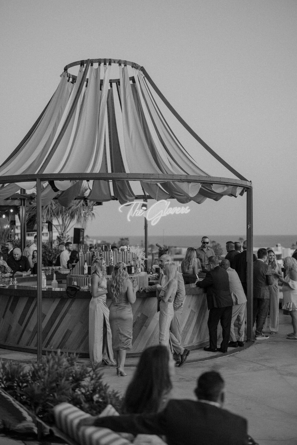 Cocktail hour at a Cabo wedding with a custom neon sign
