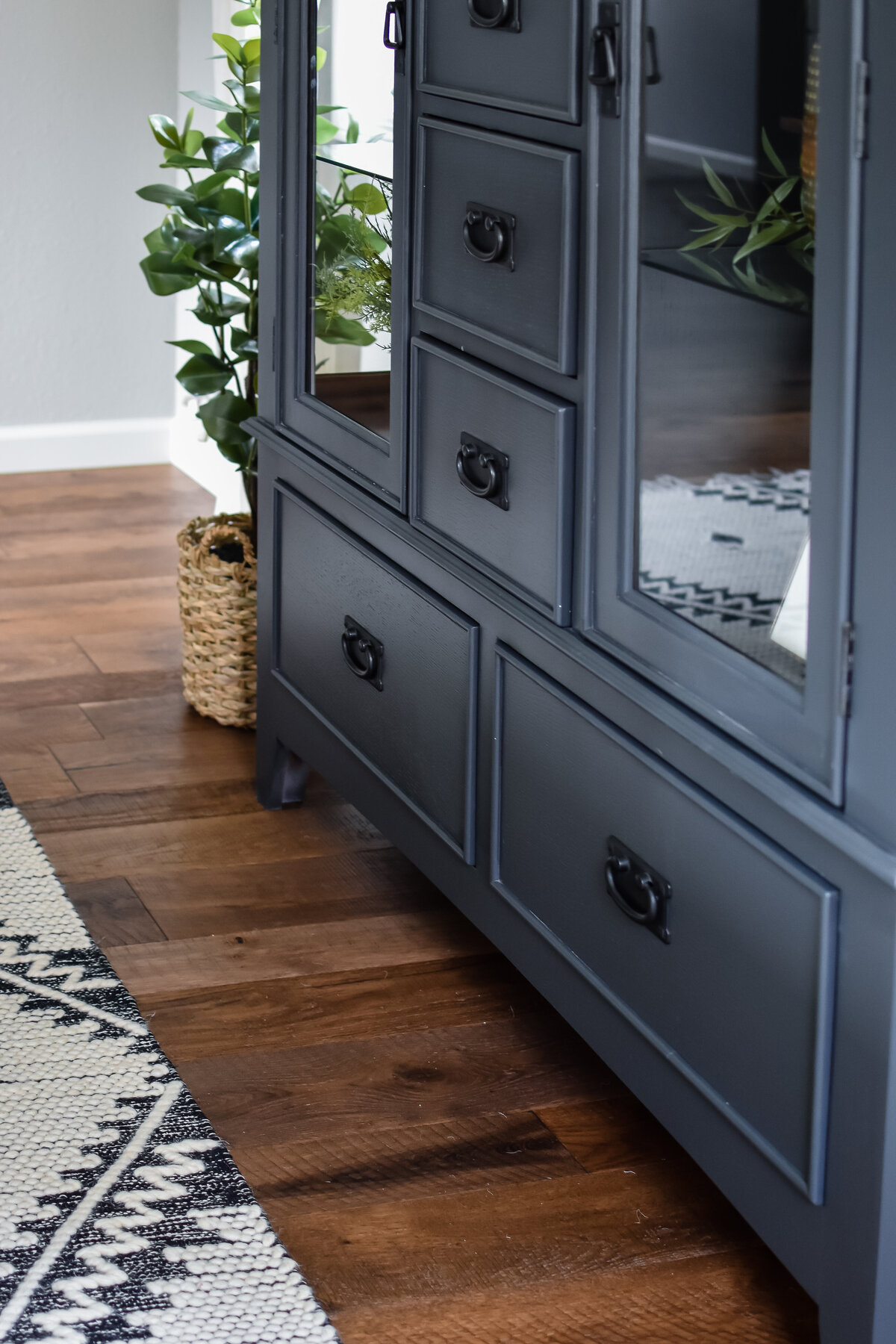 A black dining room storage hutch with multiple drawers