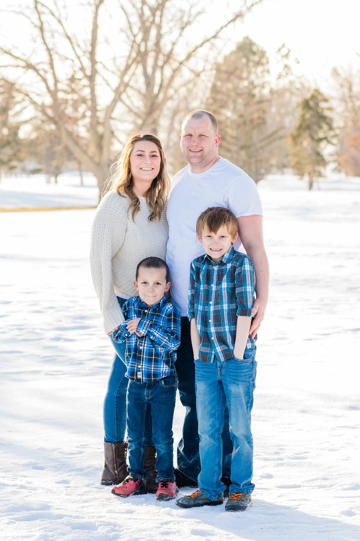 Family standing in snow looking at the camera