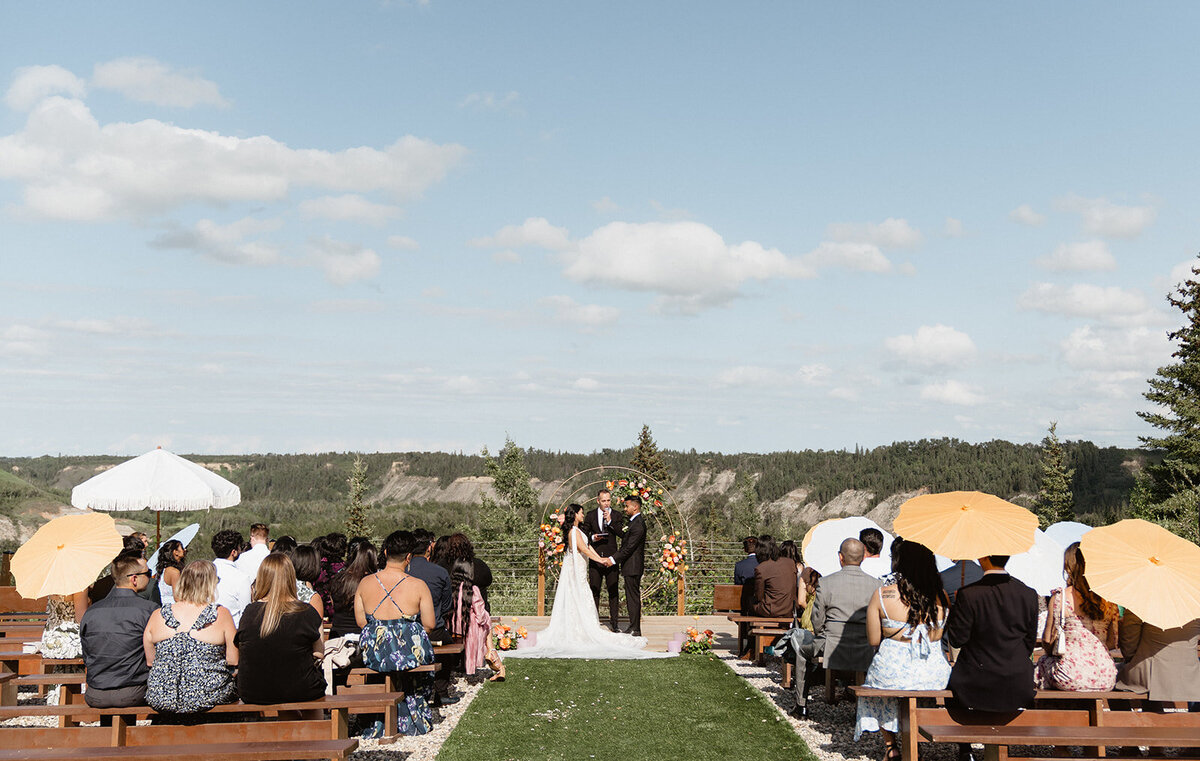 Colourful outdoor summer wedding ceremony at River's Edge in Devon Alberta