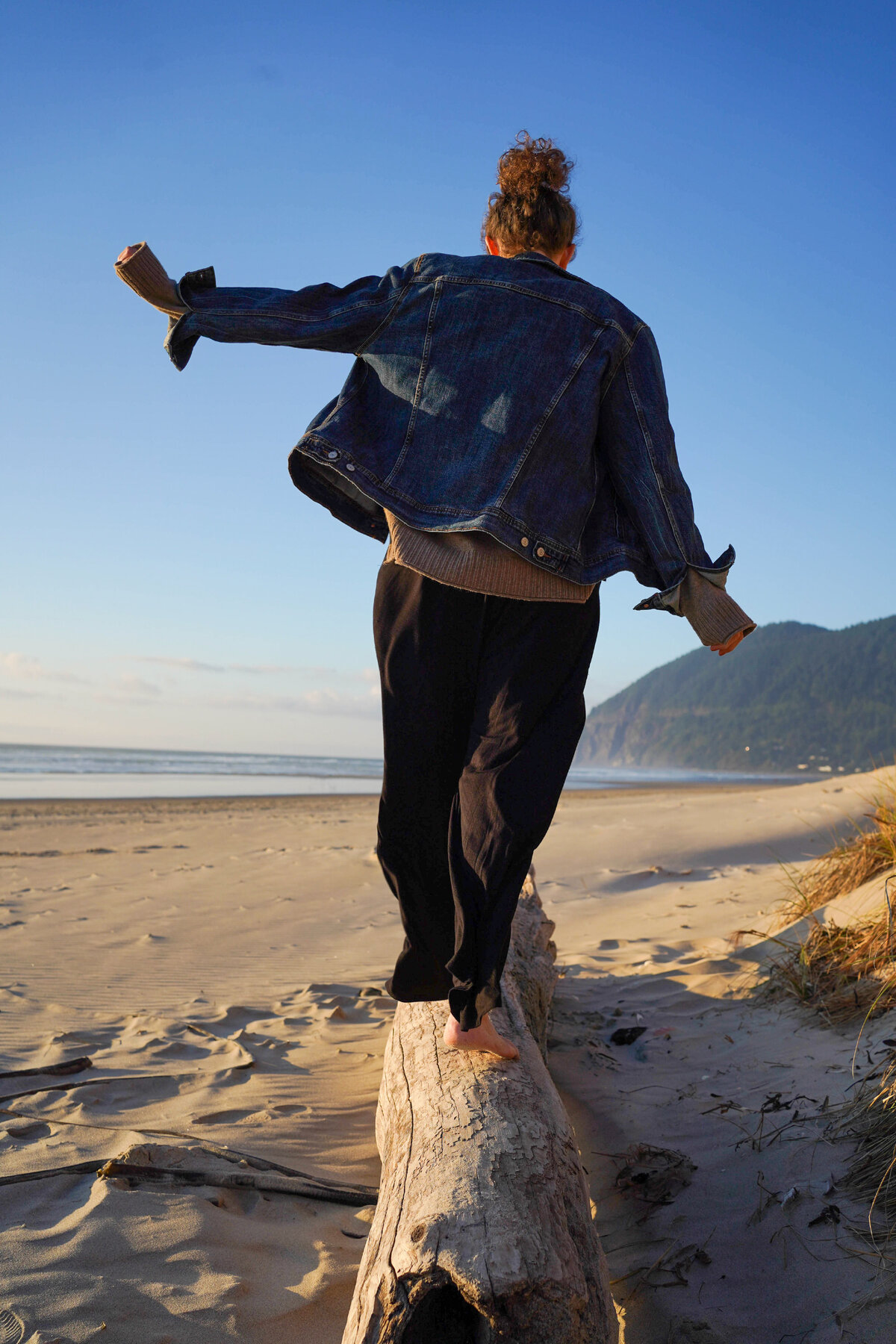 Woman walking on a beach log