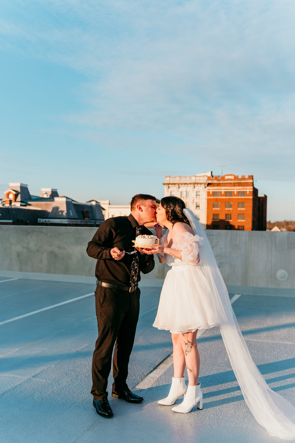  City rooftop elopement with bride's veil blowing in the wind during kiss 