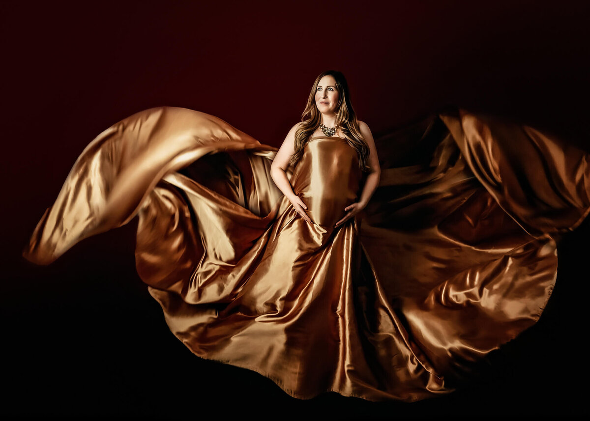 Greater Toronto expectant mom looking like a goddess in a tossed silk fabric at her in studio maternity photography session.