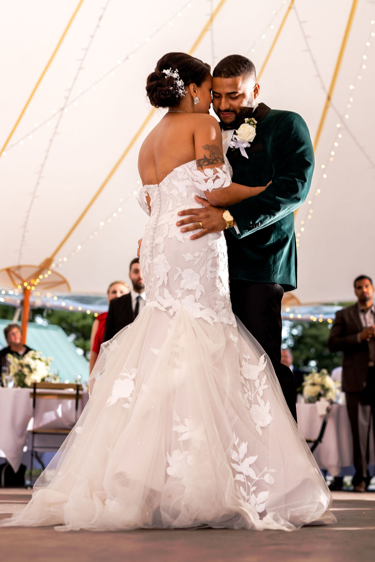 Bride and grooms first dance at beautiful tented wedding at The Gardens at Uncanoonuc Mountain in Goffstown NH. Groom in forest green jacket. By Lisa Smith Photography