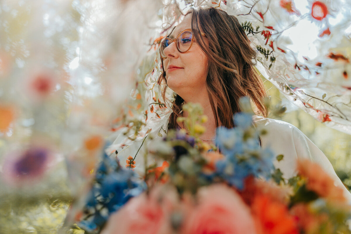 A moment captured by a Hood River Wedding Photographer of a bride hiding under her colorful veil with matching bouquet