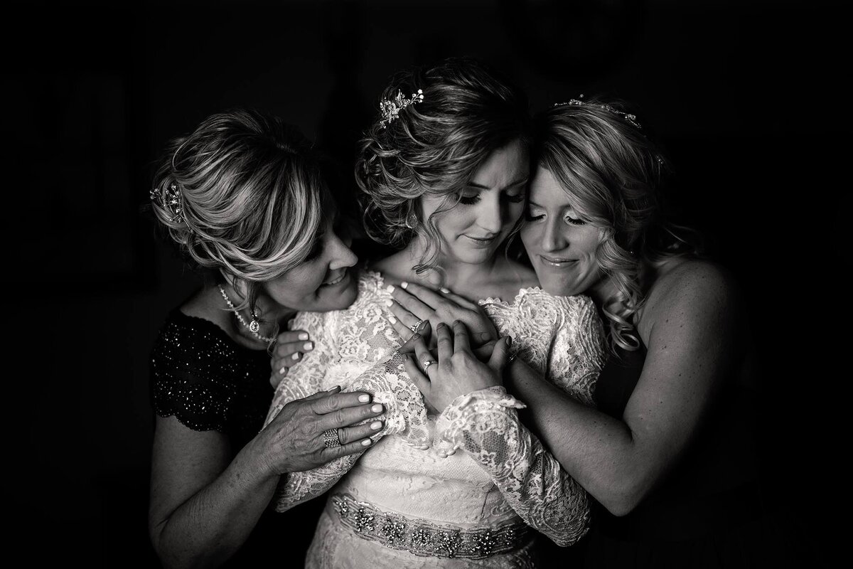 black-and-white-bride-mother-and-sister-hug-and-love-before-wedding
