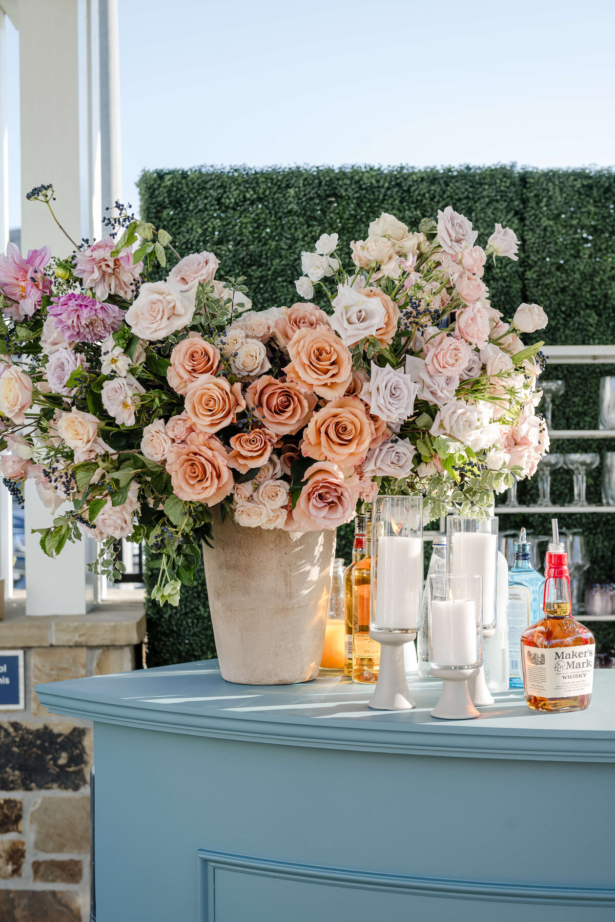 Custom bar at a Los Angeles wedding with large floral arrangements