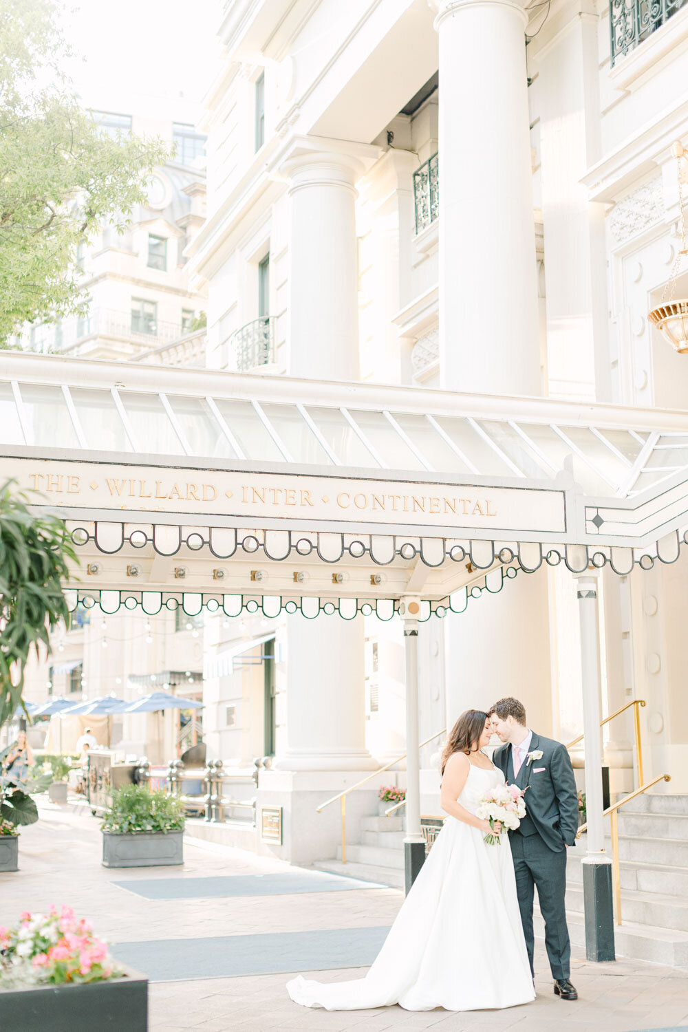 Bride and groom kiss under hotel canopy