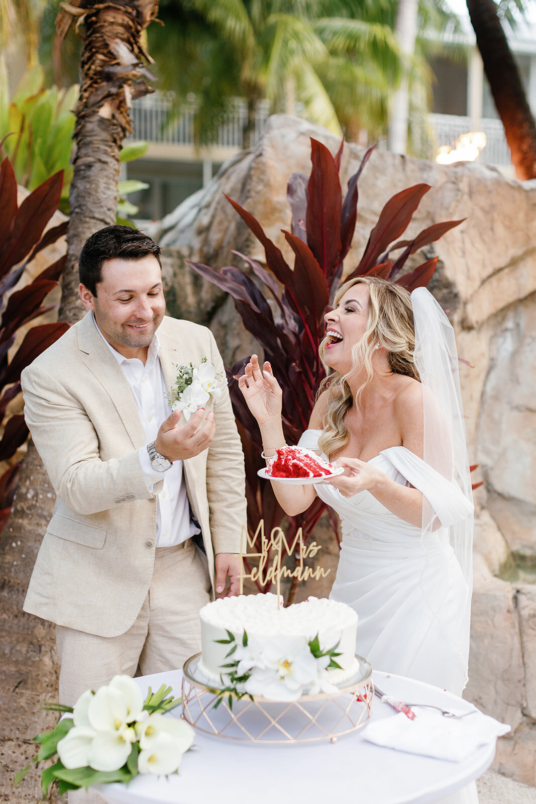 Monica and Austyn share a sweet moment as they cut their floral-adorned wedding cake in the Florida Keys.
