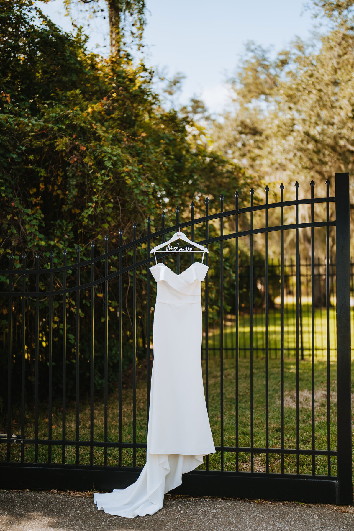 bride dress hanging from black iron gate at private residence in dunedin florida