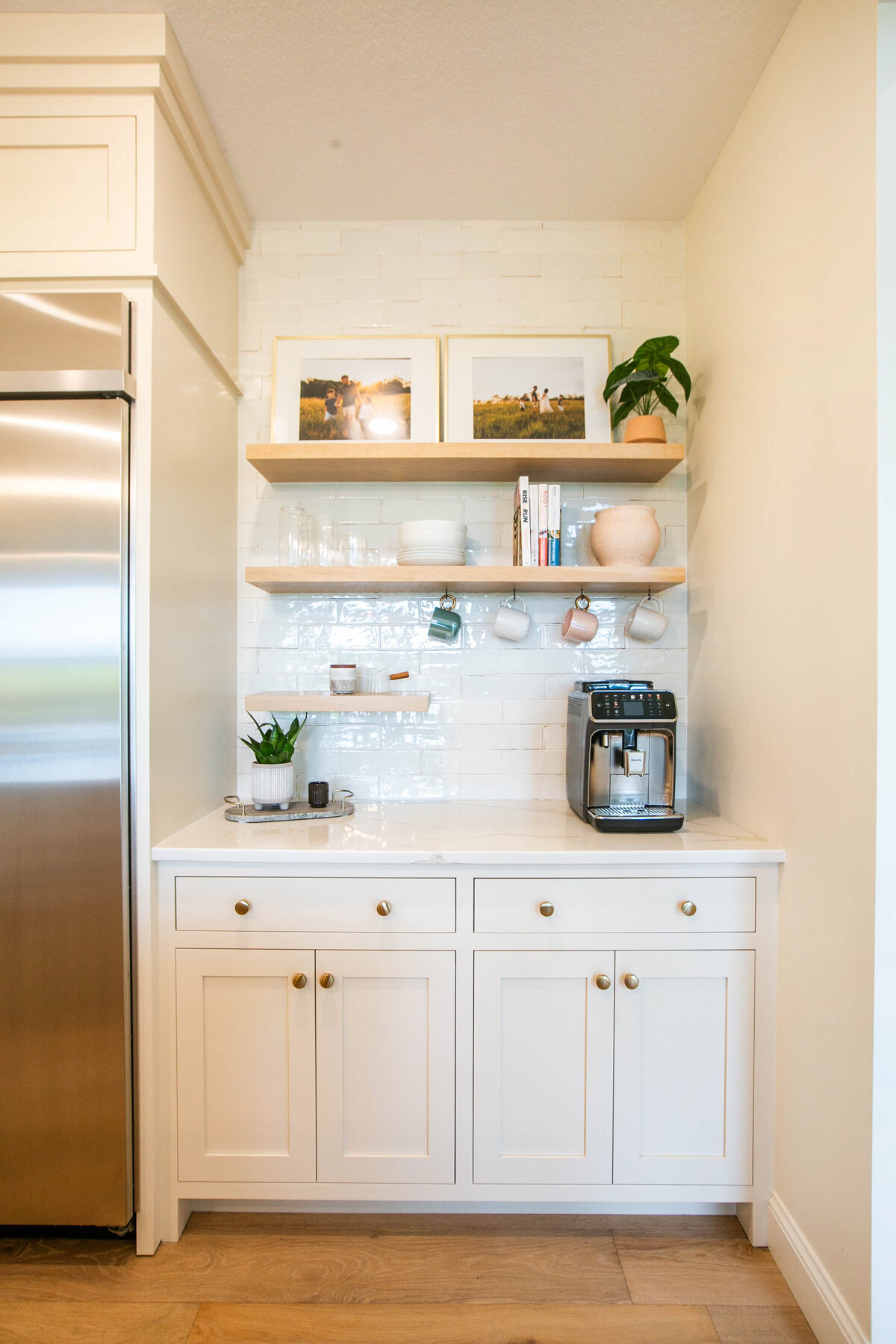 Open kitchen with white cabinets, large island, and quartz countertops in an Otsego custom home