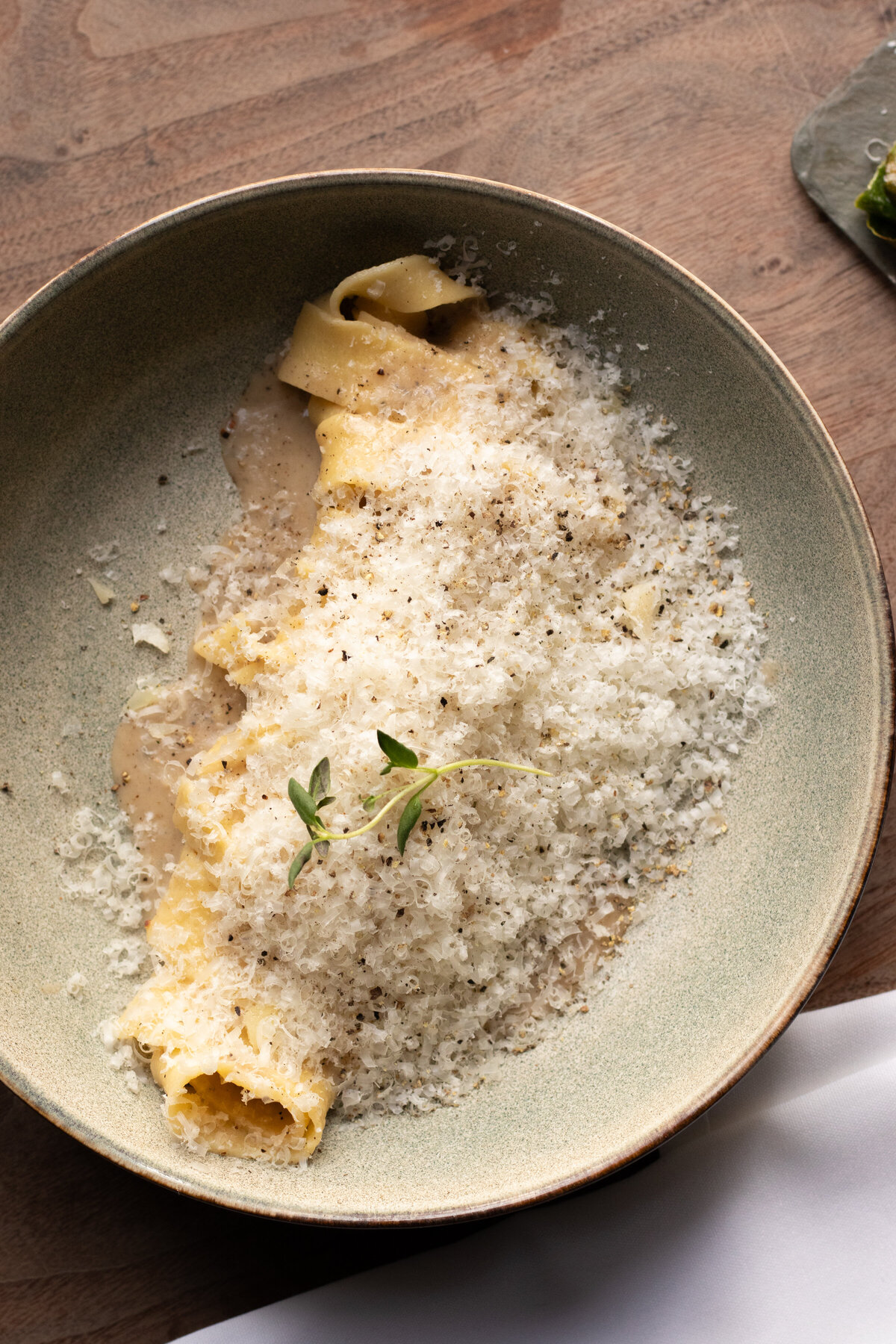 a plate of pasta topped with hand shredded cheese