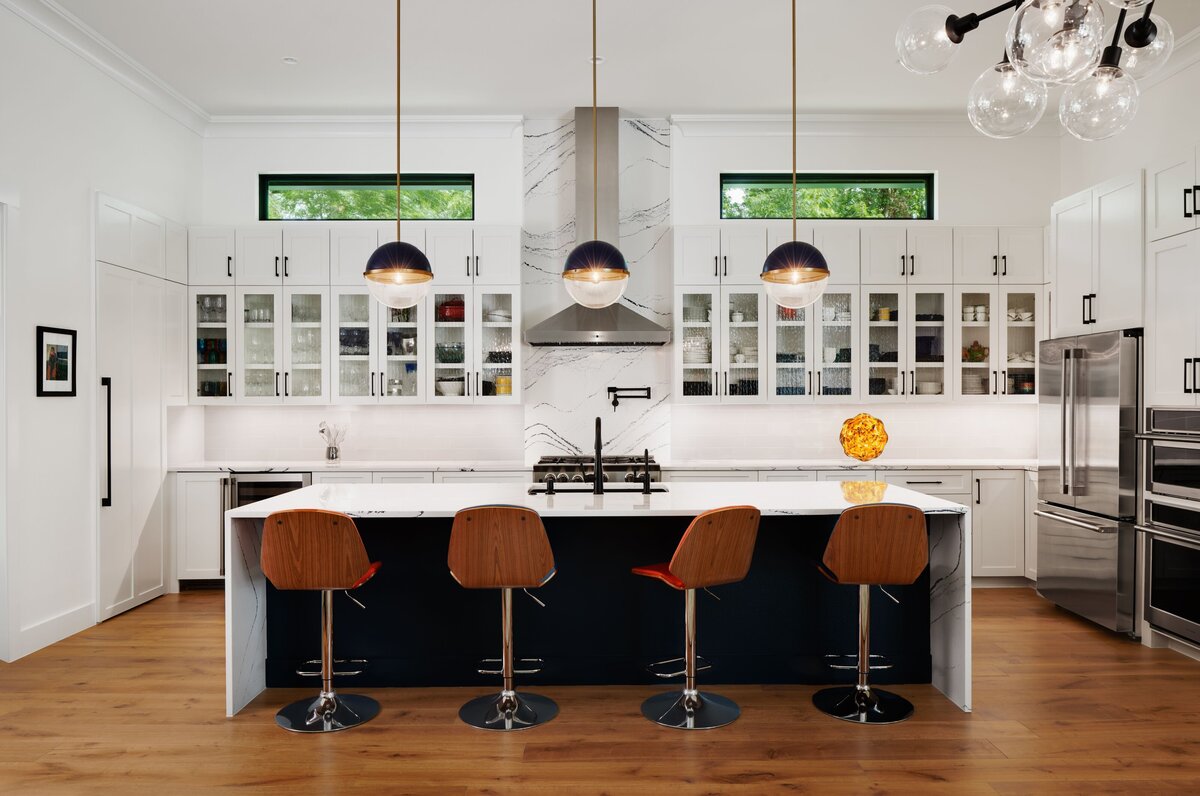 custom modern kitchen with island, bar stools, and hanging light fixtures