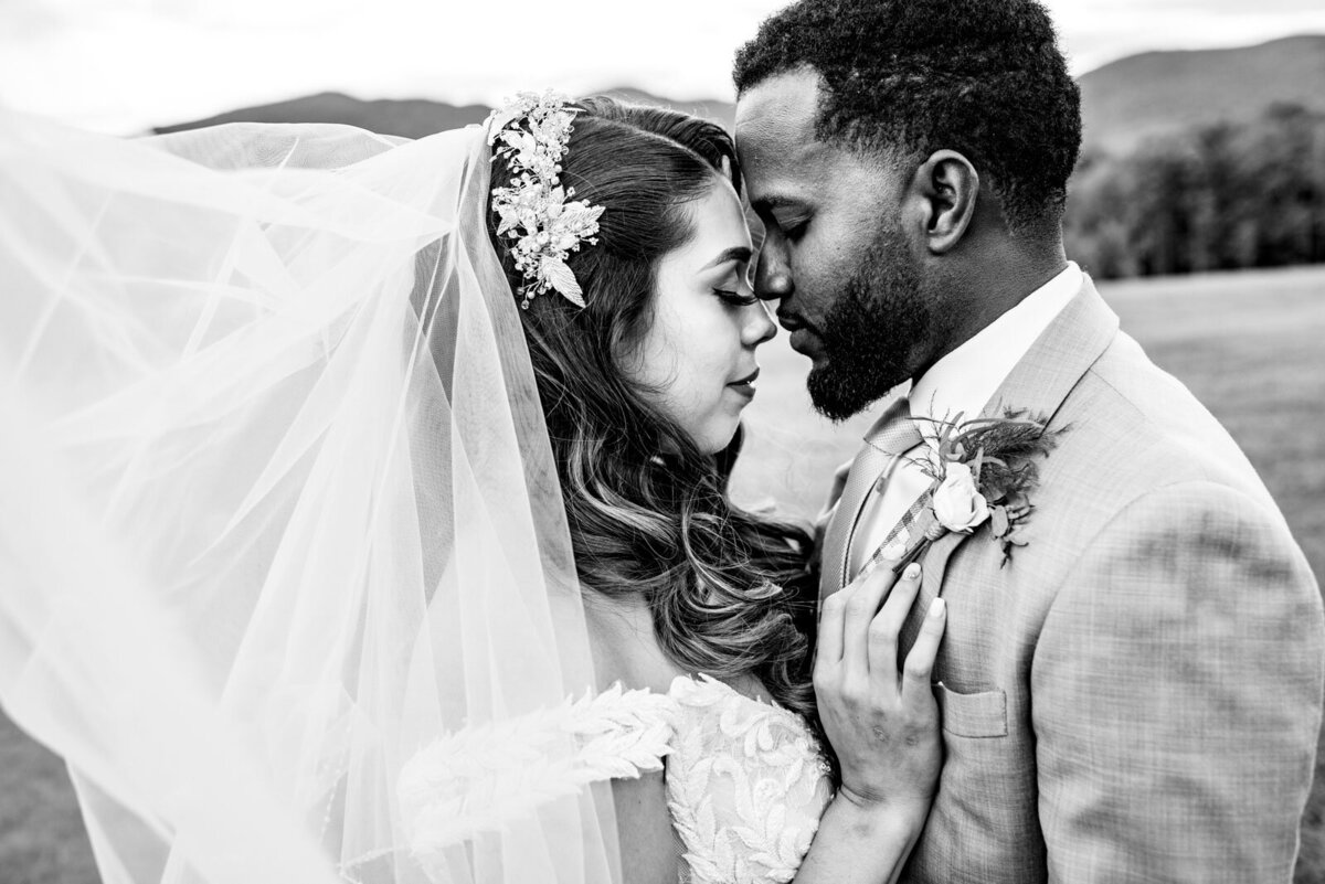 black and white couple facing each other with wedding veil blowing in the breeze at mountain top inn and resort chittenden vermont