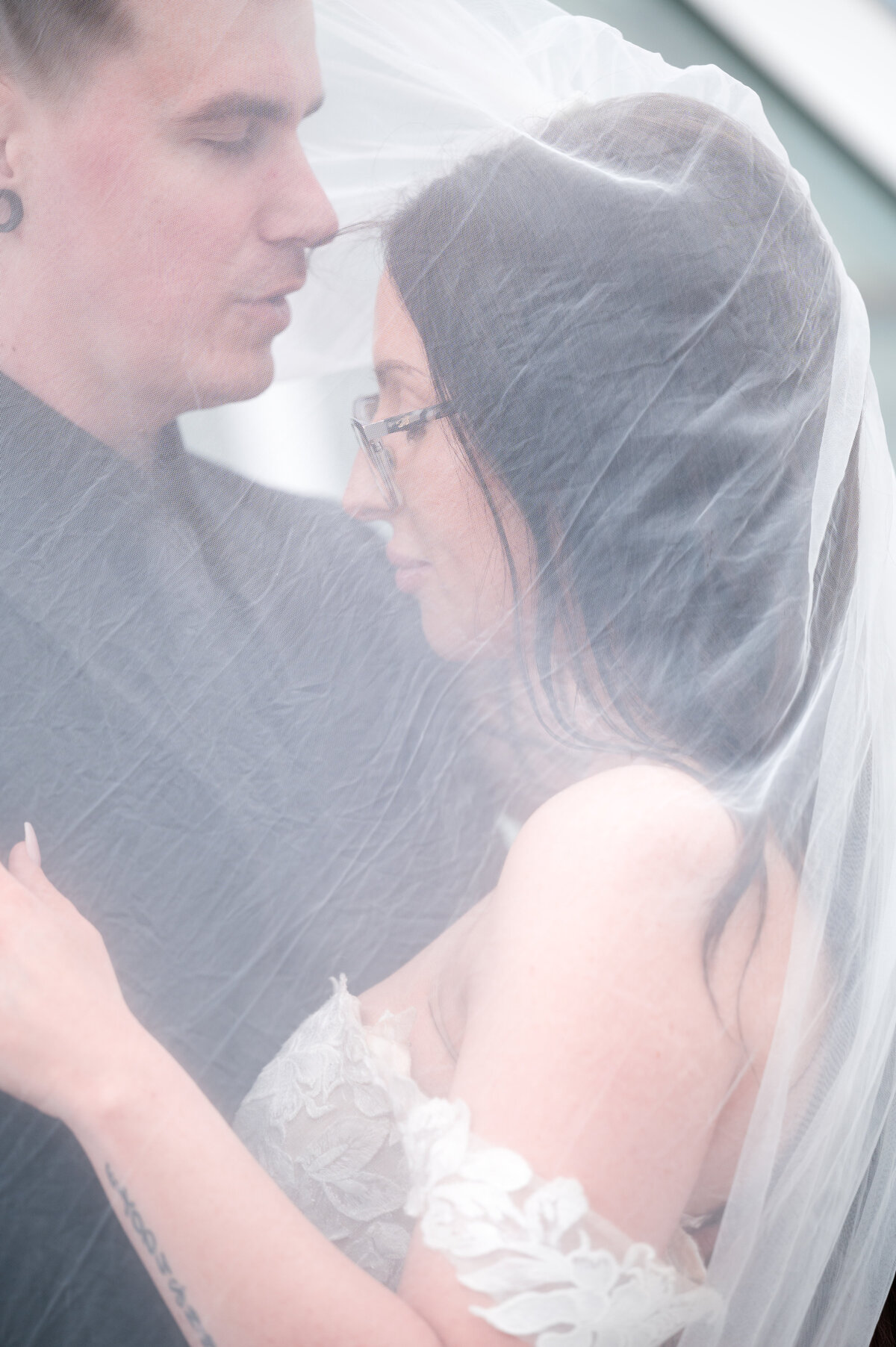 close up of bride and groom under a veil