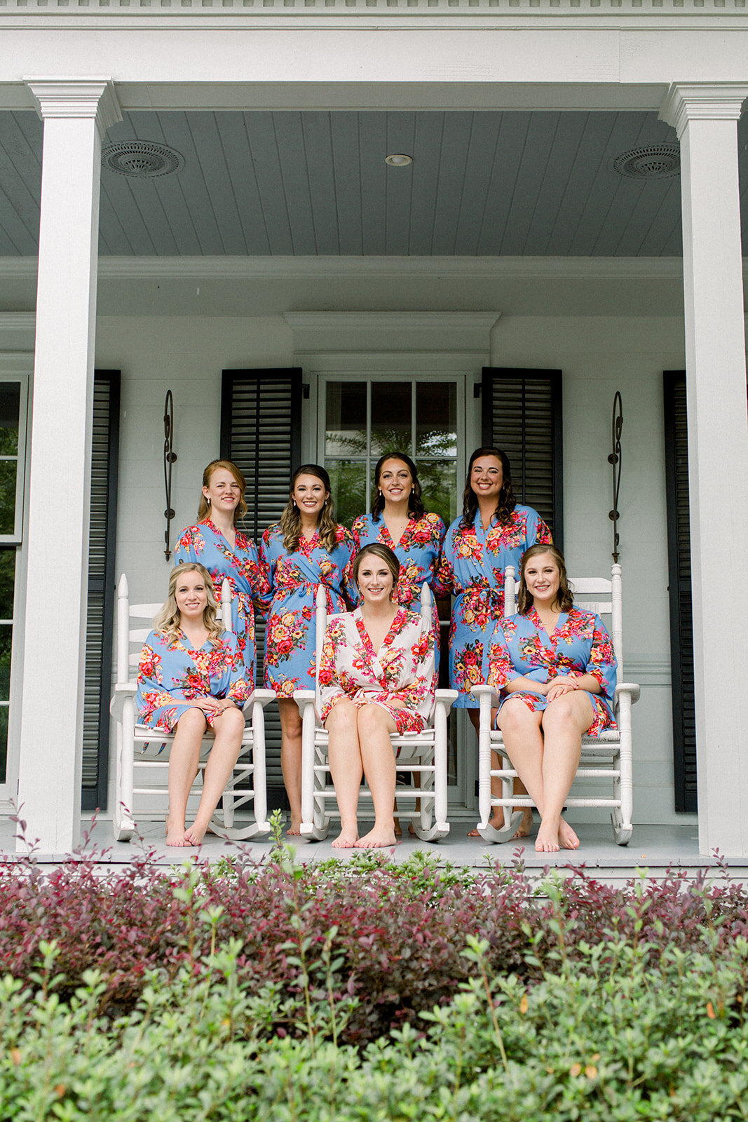 bride with bridesmaids in matching robes sitting in rocking chairs