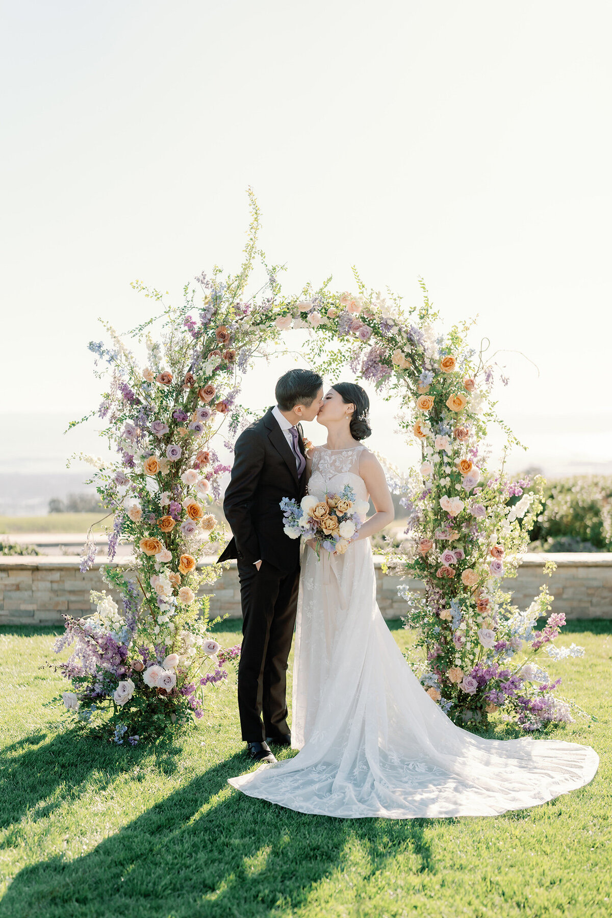 lavender and honey flowers form this ceremony arch for this bride and groom's wedding overlooking the san francisco bay