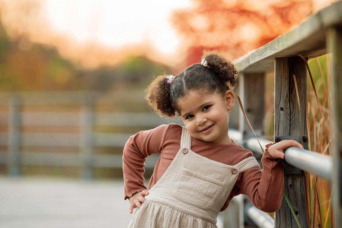 Little girl with her hand on her hips in the golden hour for her fall family photos in Burlington, ON