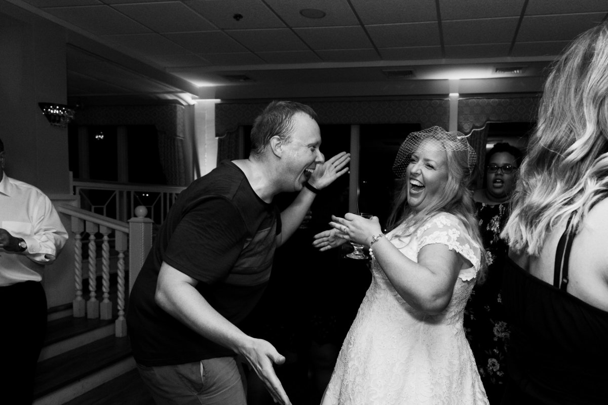 dancing, laughing bride with friend