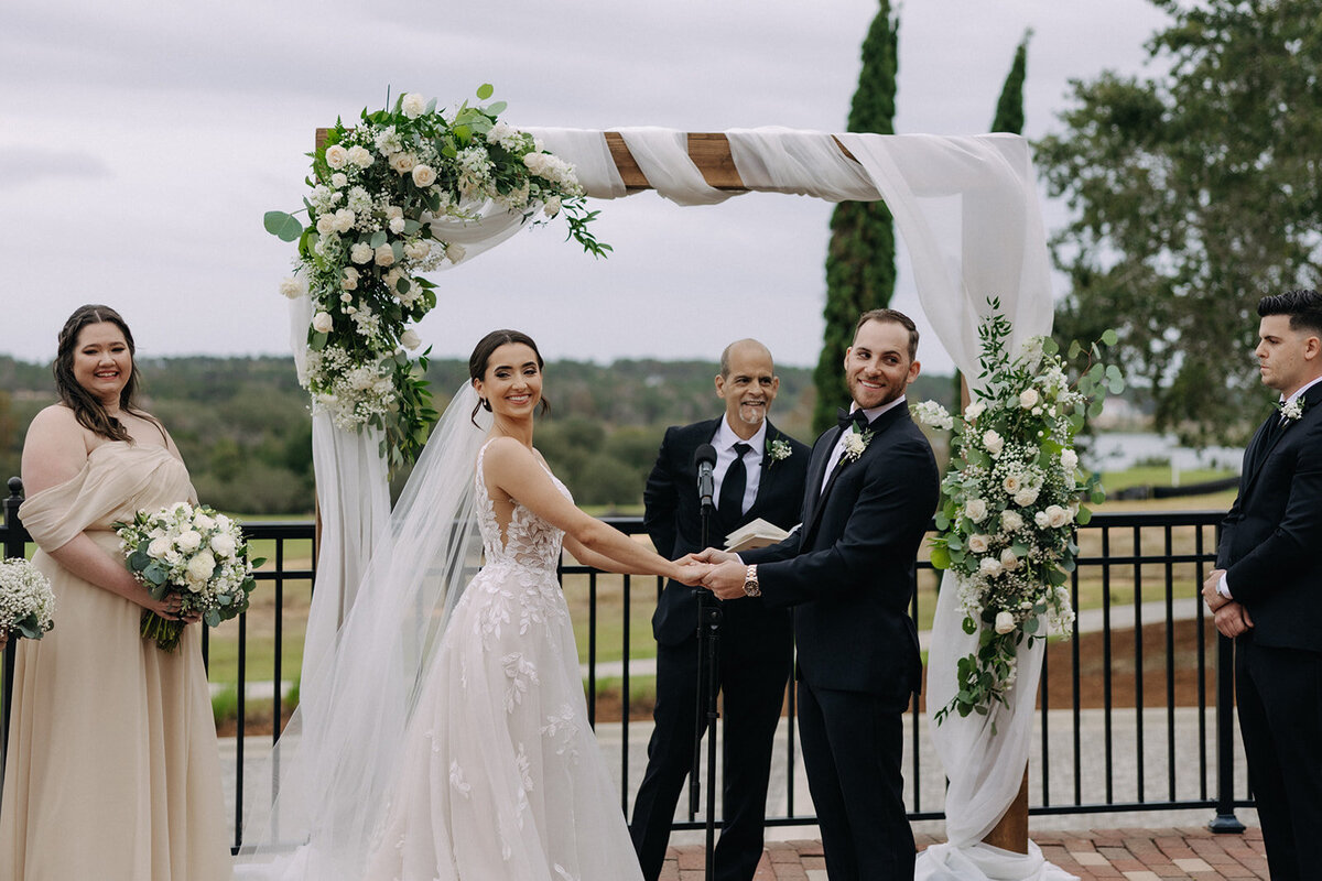 bride and groom holding hands at bella collina orlando wedding​