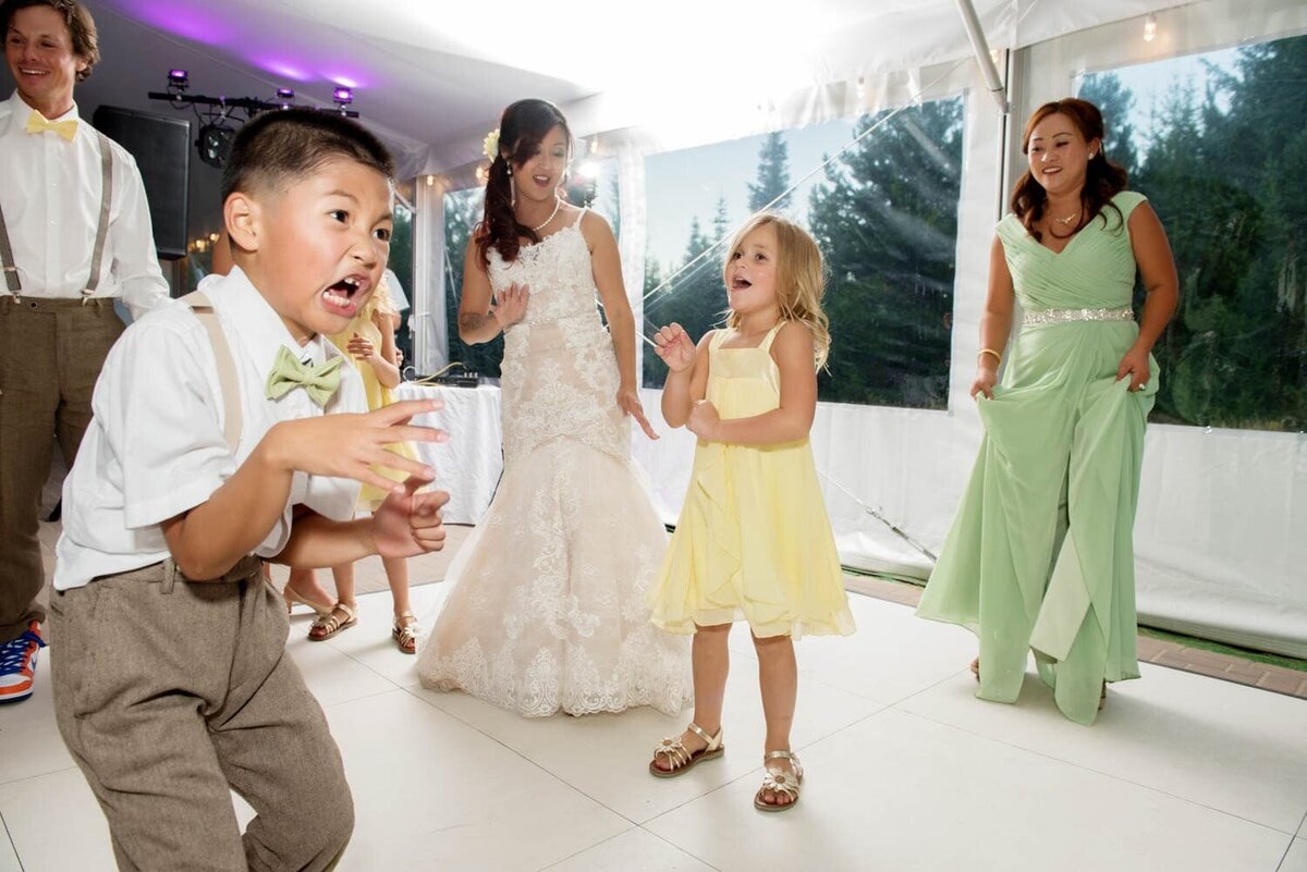 a little boy and girl dance silly and sing in the middle of a dance floor during a wedding reception