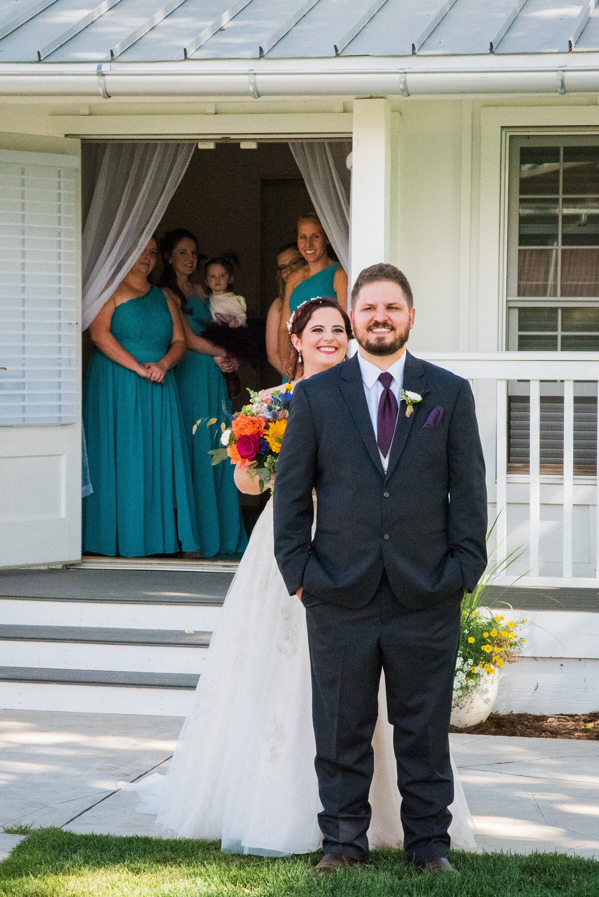 A bride approaches her groom for their first look at The Barn at Raccoon Creek as the bridesmaids watch in the background.