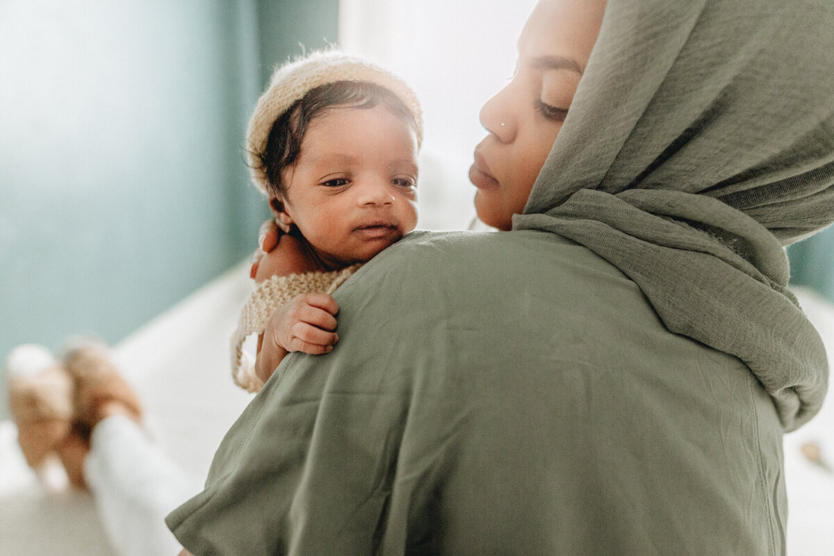 Newborn photographer capturing mom holding infant babe