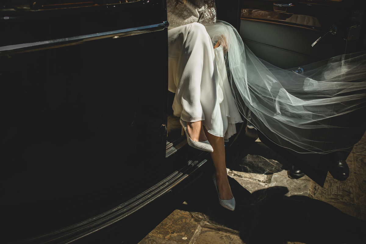 a bride stepping out of the wedding car