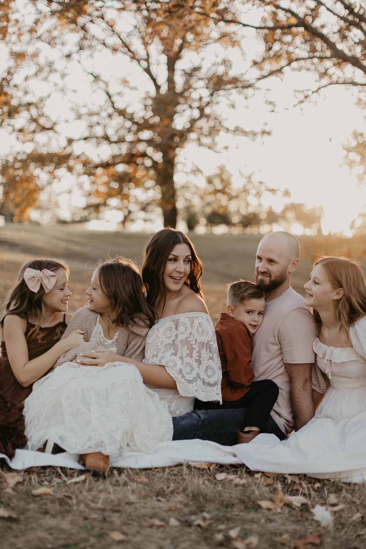 Family of 6 laughing and sitting together. 