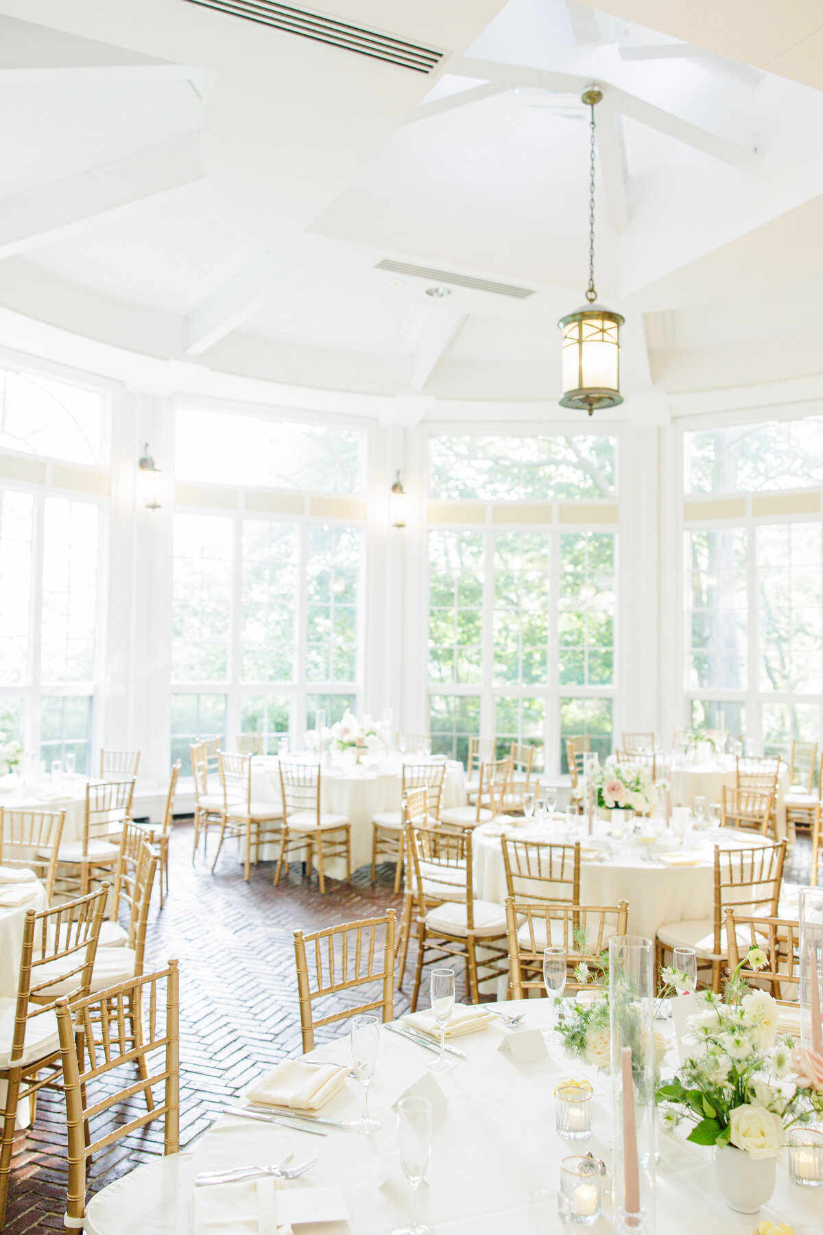 Wedding reception tables decorated with white florals at Tupper Manor