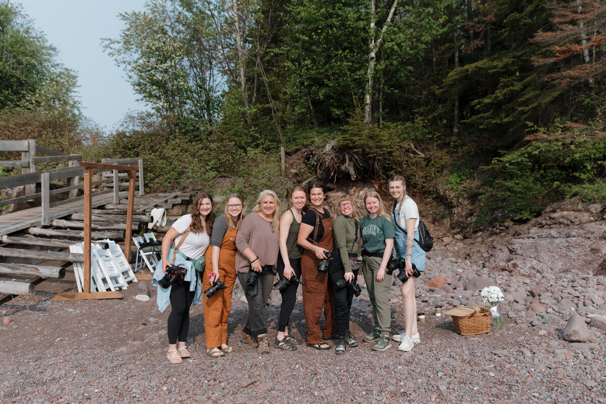 A group of photographers standing on a hiking trail smiling 