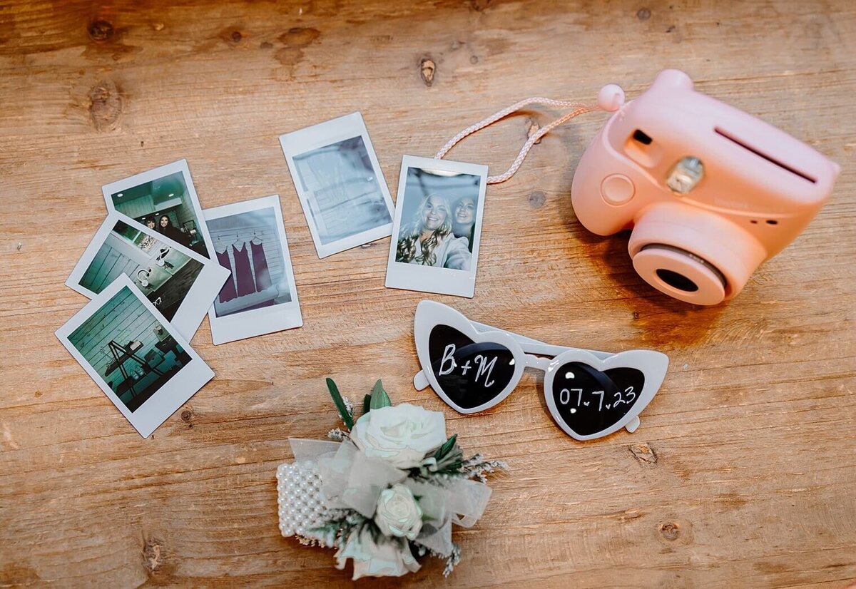 Wedding details including polaroid photos, glasses, and camera
