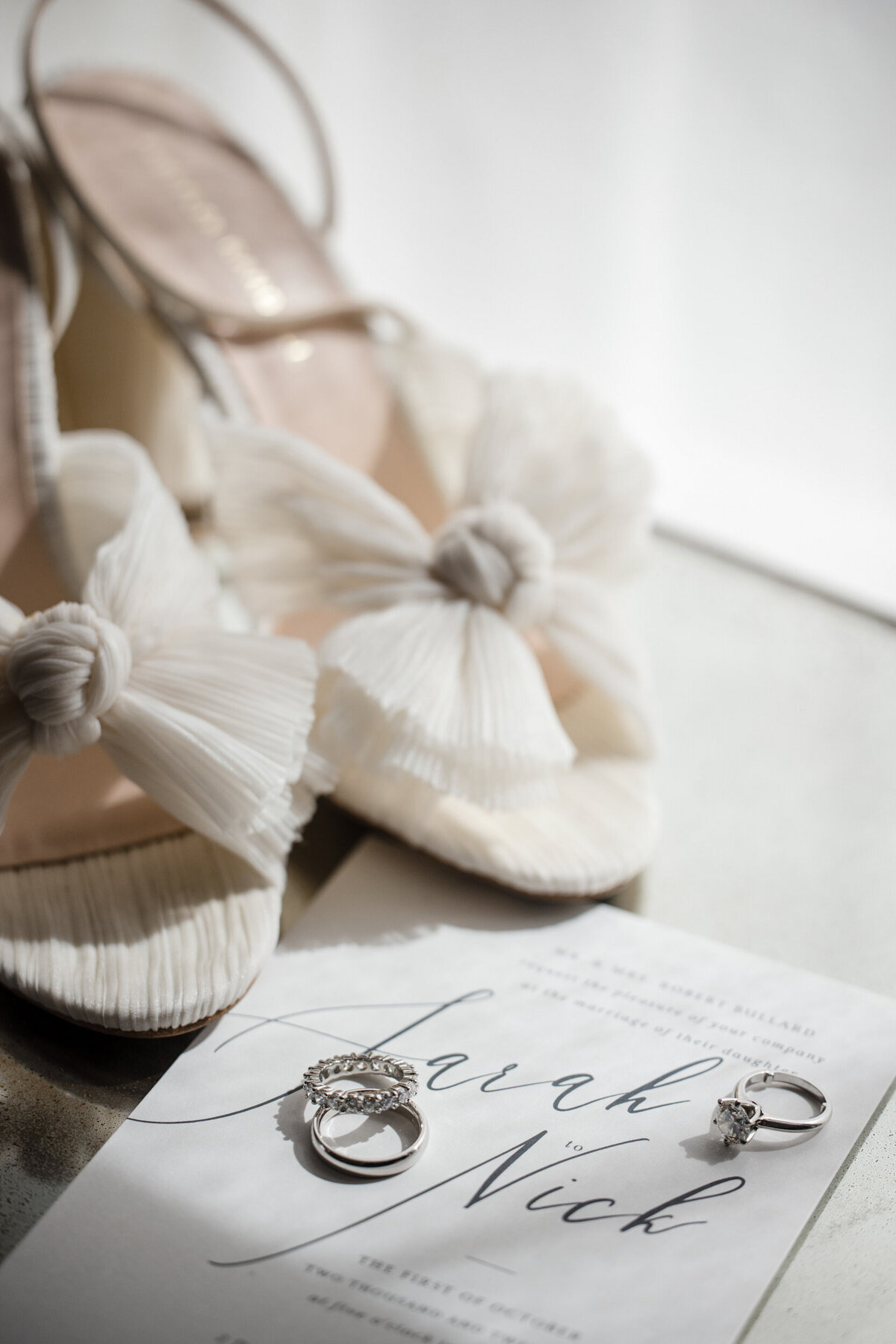 A flatlay with shoes, rings, and an invitation at a Beekman Hotel wedding