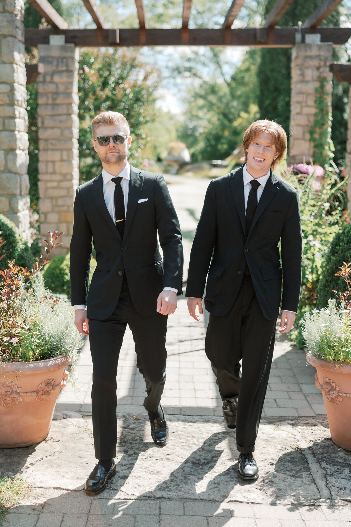Groom and groomsman walk garden aisle at Dayton wedding, by Philadelphia wedding photographer.