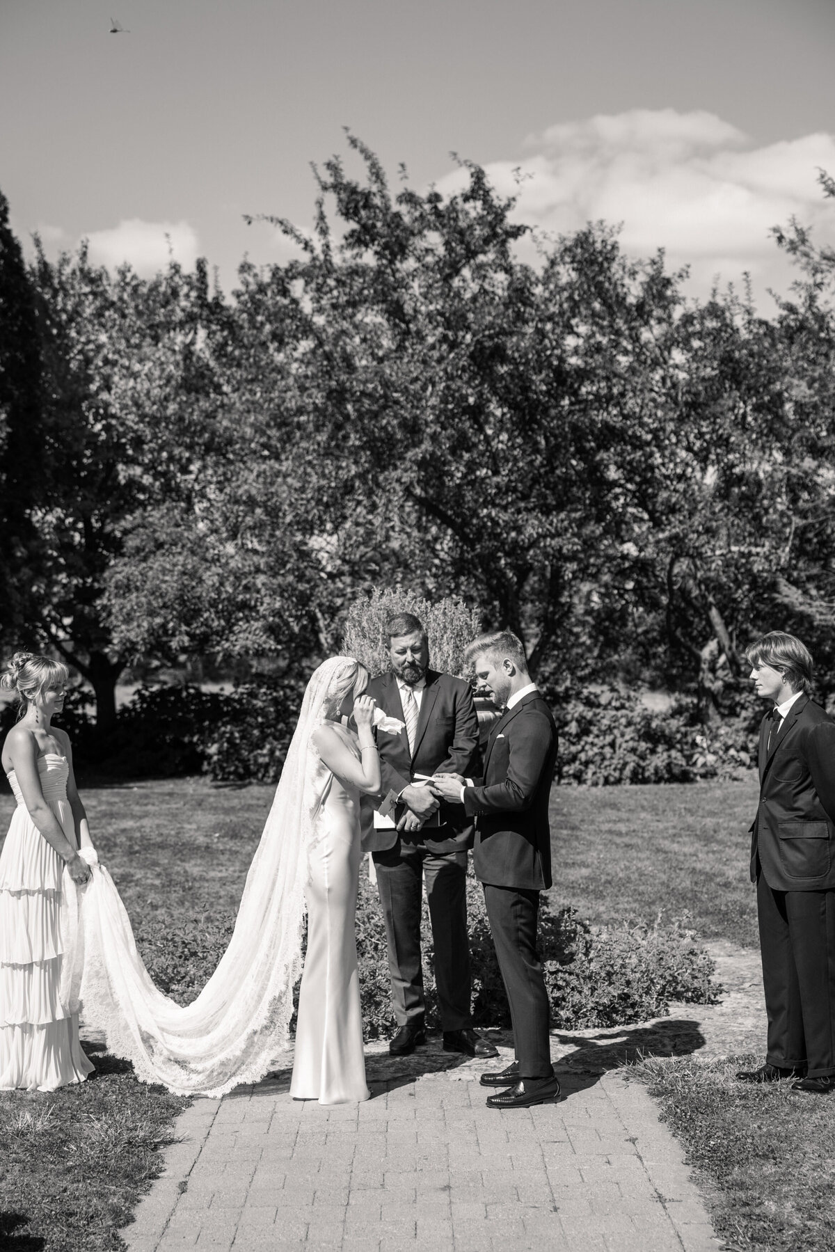 Bride wipes tears as groom reads vows at garden ceremony in Dayton, Ohio, photo by Philadelphia photographer.