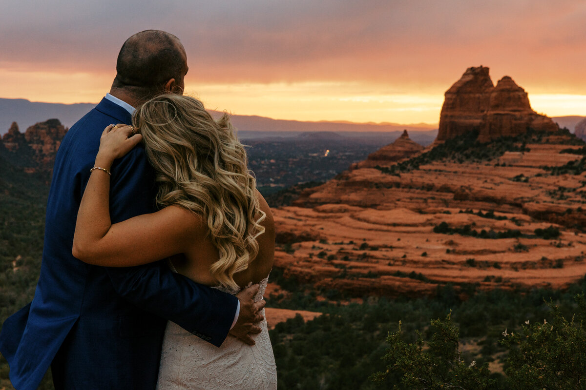 bride and groom looking over sunset