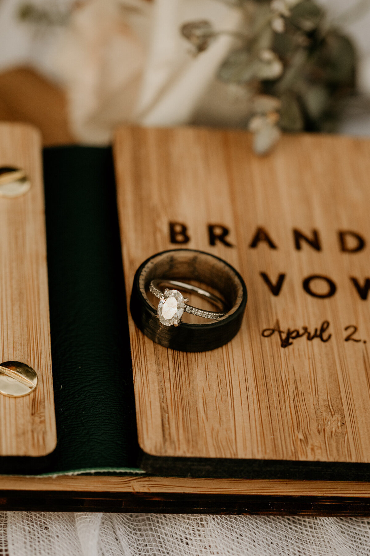 bride and groom rings with wooden vow books