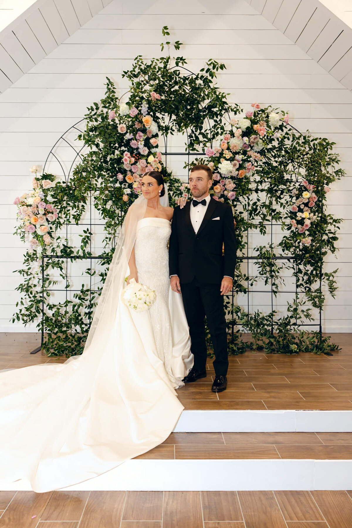 A wedding photo of the bride and groom posing for a photo after their ceremony