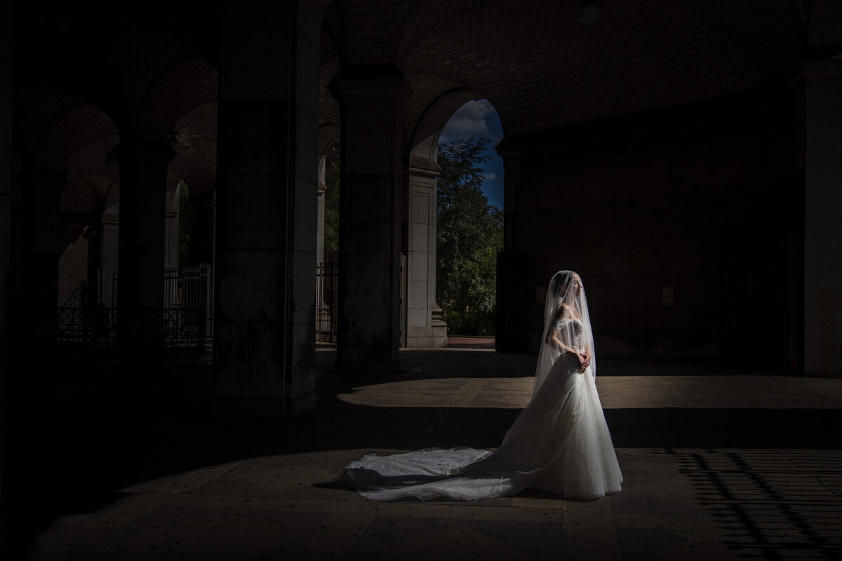 A bride poses for portraits on a NYC subway platform on her wedding day