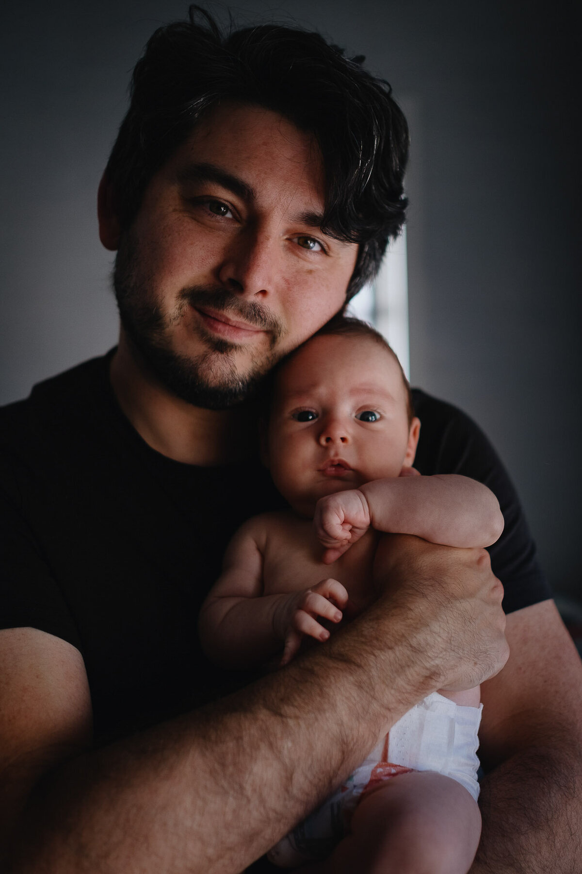 Portrait of dad and his newborn son during a santa monica newborn photoshoot.