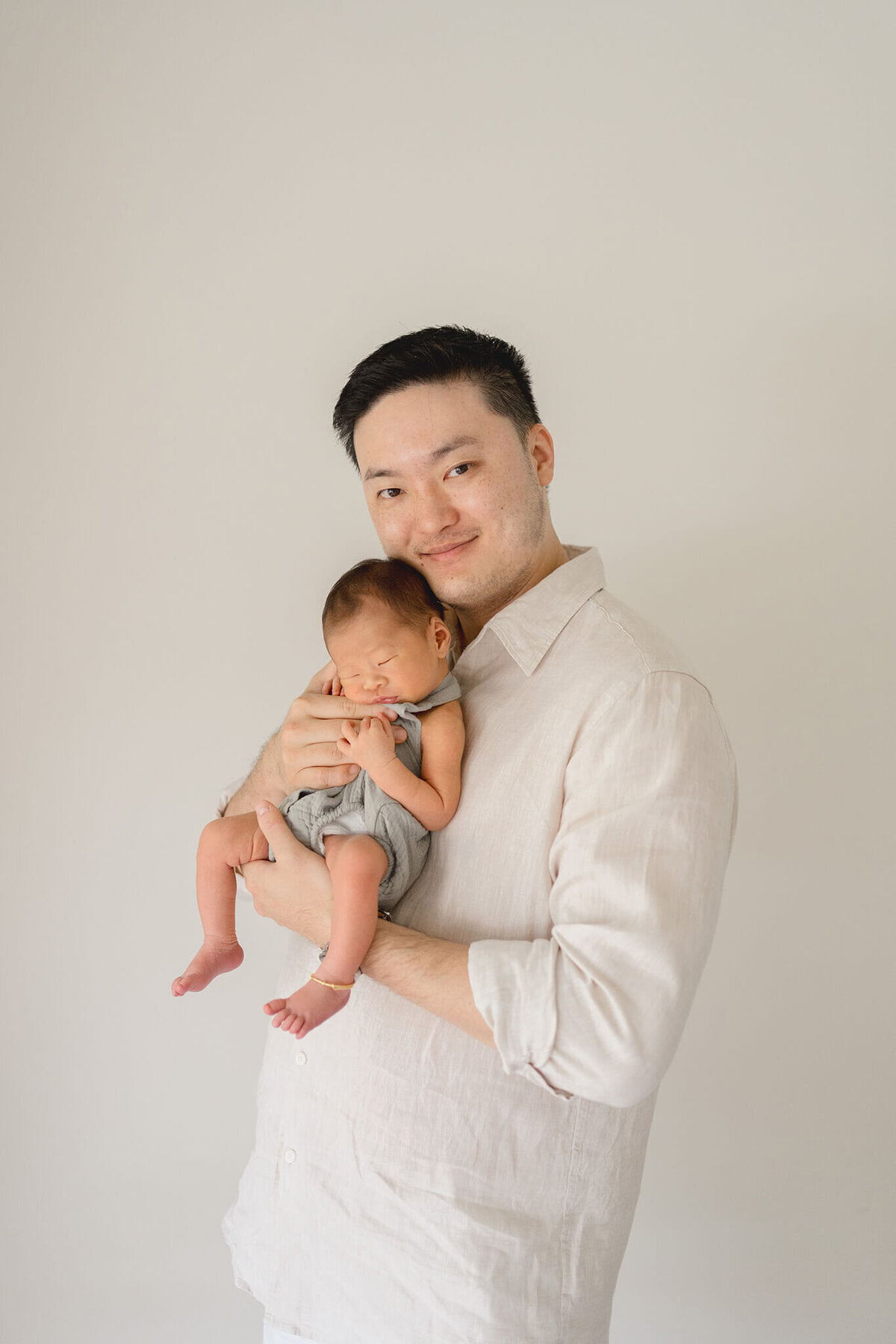 Celebrate the miracle of life as first-time Chinese dad cuddle their newborn in endearing Gold Coast maternity photos.