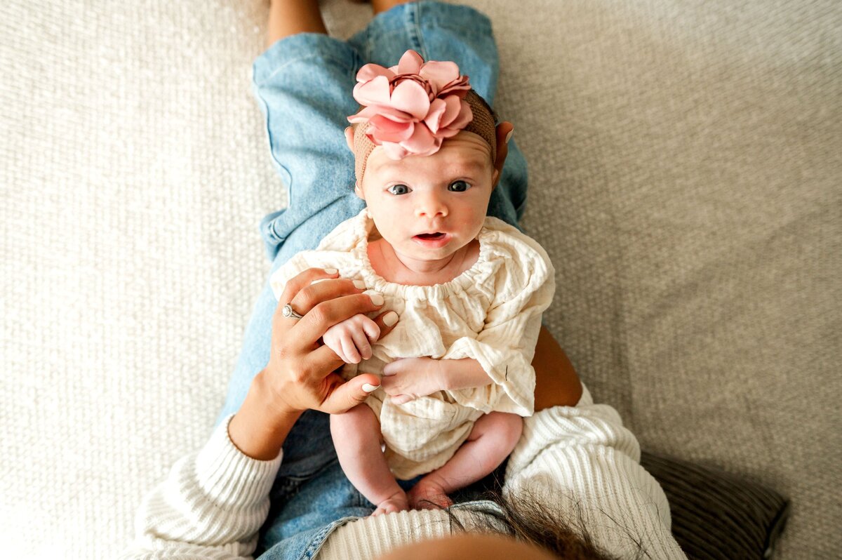newborn 3 week old baby looking up t her mom