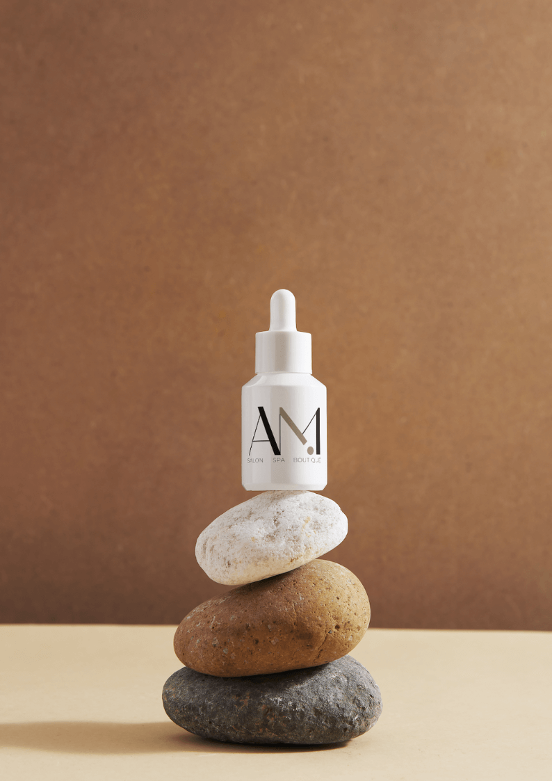 Logo for a salon company on a tincture bottle on top of three rocks