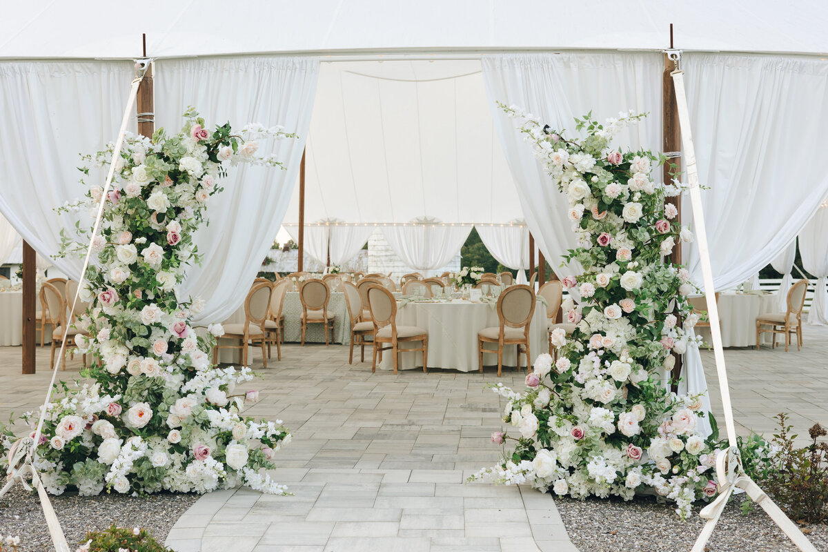 Floral arch at the entrance to the sailcloth tent